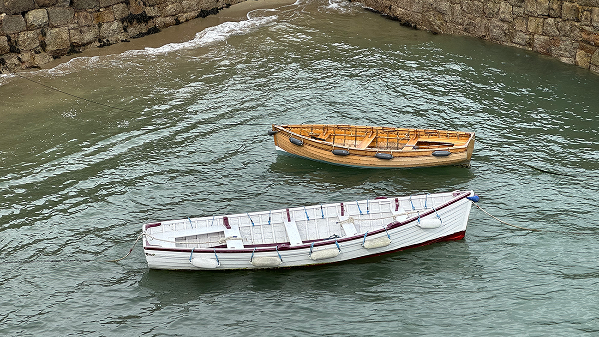 Photo of two wooden boats floating in the harbor.